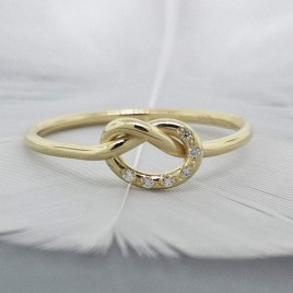 Solid gold love knot ring with tiny diamonds